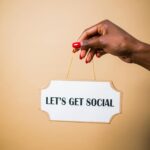 A hand holding a "Let's Get Social" sign, ideal for marketing and social media themes.